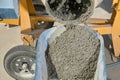 Mixer pouring wet cement into wheelbarrow close up Royalty Free Stock Photo