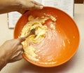 Mixing banana bread in orange bowl