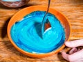 Mixing blue food coloring in bowl of liquid dough Royalty Free Stock Photo