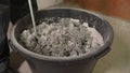 Builder mixing plaster in a bucket using an electric mixer. Mixing cement putty in a bucket using a construction mixer.