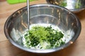 mixing chopped parsley, lime zest and sour cream in a metal bowl