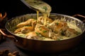 mixing cooked chicken in the creamy sauce