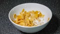 Mixing cornflakes and milk in bowl with spoon and eating for breakfast. Royalty Free Stock Photo
