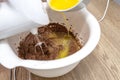 Mixing the dough with a hand mixer with a whisk with melted butter added, the dough is in a thick liquid brown mass.