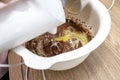 Mixing the dough with a hand mixer with a whisk with melted butter added, the dough is in a thick liquid brown mass.