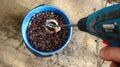 mixing a grape mixture in a bucket with a tool