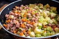 mixing leftover meat and veggies for bubble and squeak