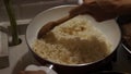 Stirring rice, heating rice in the pan on the stove