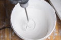 Mixing wall putty with a whisk in a bucket, for finishing application Royalty Free Stock Photo