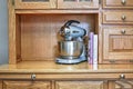 Mixmaster blender with cookbooks on shelf of oak sideboard