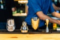 Mixologist making cocktail with Shaker, Double Size Jiggers and drinking glass with ice cube on cocktail counter bar Royalty Free Stock Photo