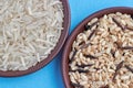 A mixture of brown and black unpolished wild rice in polished white basmati rice in clay ceramic bowls close-up on a Royalty Free Stock Photo