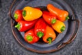 Mixture of chilli shaped red, orange and yellow capsicums pepper vegetables in bowl