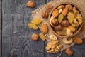 A mixture of dried fruits and nuts in a wooden bowl on a piece of burlap on a wooden table. Flat lay Royalty Free Stock Photo