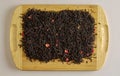 A mixture of dry black tea and pieces of dried strawberries as a background. Isolated on a wooden surface Royalty Free Stock Photo