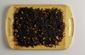 A mixture of dry black tea and dry tea rose petals as a background. Isolated on a wooden surface Royalty Free Stock Photo