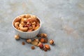 A mixture of nuts and dried fruits in a white cup on a gray background with space to copy. Royalty Free Stock Photo