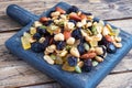 A mixture of nuts and dried fruits on a wooden chopping board, rustic background. Concept of healthy food Royalty Free Stock Photo