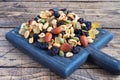 A mixture of nuts and dried fruits on a wooden chopping board, rustic background. Concept of healthy food Royalty Free Stock Photo