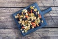 A mixture of nuts and dried fruits on a wooden chopping board, rustic background. Concept of healthy food Royalty Free Stock Photo