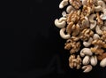 Mixture of nuts peanuts, pistachios, almonds, walnuts, hazelnut, cashew from top view with black background with copy space Royalty Free Stock Photo