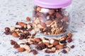 A mixture of nuts and raisins scattered on a table from a glass jar. Royalty Free Stock Photo