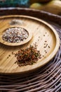 Mixture of spices for baking on a wooden plate. Includes flax sesame and sunflower seeds