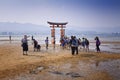 MIYAJIMA, JAPAN - MAY 27: Asian Tourists in front of famous floating torii gate of the Itsukushima Shrine on Miyajima at sunset on Royalty Free Stock Photo