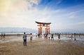 MIYAJIMA, JAPAN - MAY 27: Tourists walk around the famous floating torii gate of the Itsukushima Shrine on Miyajima at sunset on Royalty Free Stock Photo