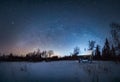 Mlky way Arc in the night sky above snow-covered garden house in winter forest Royalty Free Stock Photo