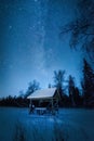 Mlky way in the night sky above snow-covered garden house in winter forest Royalty Free Stock Photo