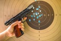 9 mm hand gun on bullseye target for shooting practice. Royalty Free Stock Photo