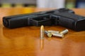 .38 mm handgun and bullets strewn on the rustic wooden table background. Gun with ammunition and  ammo or 9mm handgun on Royalty Free Stock Photo