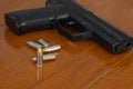 .38 mm handgun and bullets strewn on the rustic wooden table background. Gun with ammunition and ammo or 9mm handgun on