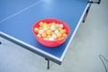 White and orange ping pong ball on ping pong table