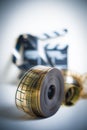 35mm movie reel with out of focus clapper in background, vertica Royalty Free Stock Photo