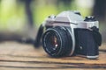 35mm SLR camera for classic photography old retro style. Black camera wide lens on wooden table outdoor. Vintage camera equipment Royalty Free Stock Photo