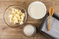 Mmargarine, wheat flour, sugar in bowls for cooking cookie, spoon on baking tray on table. Top view Royalty Free Stock Photo