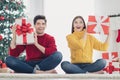 Mmm... interesting. What is that. Full length photo of surprised two people hold shake gifts from santa received in