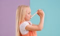 Mmm, its so chewy. A cute little girl eating candy against a colorful background. Royalty Free Stock Photo