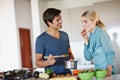Mmm, my tastebuds are doing the happy dance. a handsome young man giving his wife a taste of his cooking.