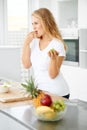 Mmmmmm So fresh. Curvaceous young woman eating grapes in her kitchen. Royalty Free Stock Photo