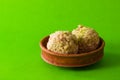 moa, popular bengali dessert is served on a clay plate. this is made of jaggery, puffed rice and made into a ball. famous sweet