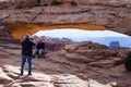 Tourists taking pictures at Mesa Arch in Canyonlands National Park