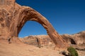 Moab, Utah - May 12, 2021: Male hiker takes photos of Corona Arch with his iPad