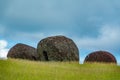 Moai pukaos over the hill under cloudy sky