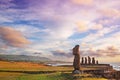 Moai statues at the Ahu Tahai Ceremonial complex on Easter Island, against a colorful sunset sky.