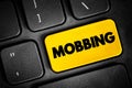 Mobbing - sociological term, means bullying of an individual by a group, text button on keyboard
