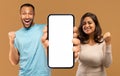 Mobile Advertisement. Joyful Black Man And Woman Demonstrating Big Blank Cellphone