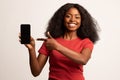 Mobile Advertisement. Smiling Black Lady Pointing On Smartphone With Blank Screen